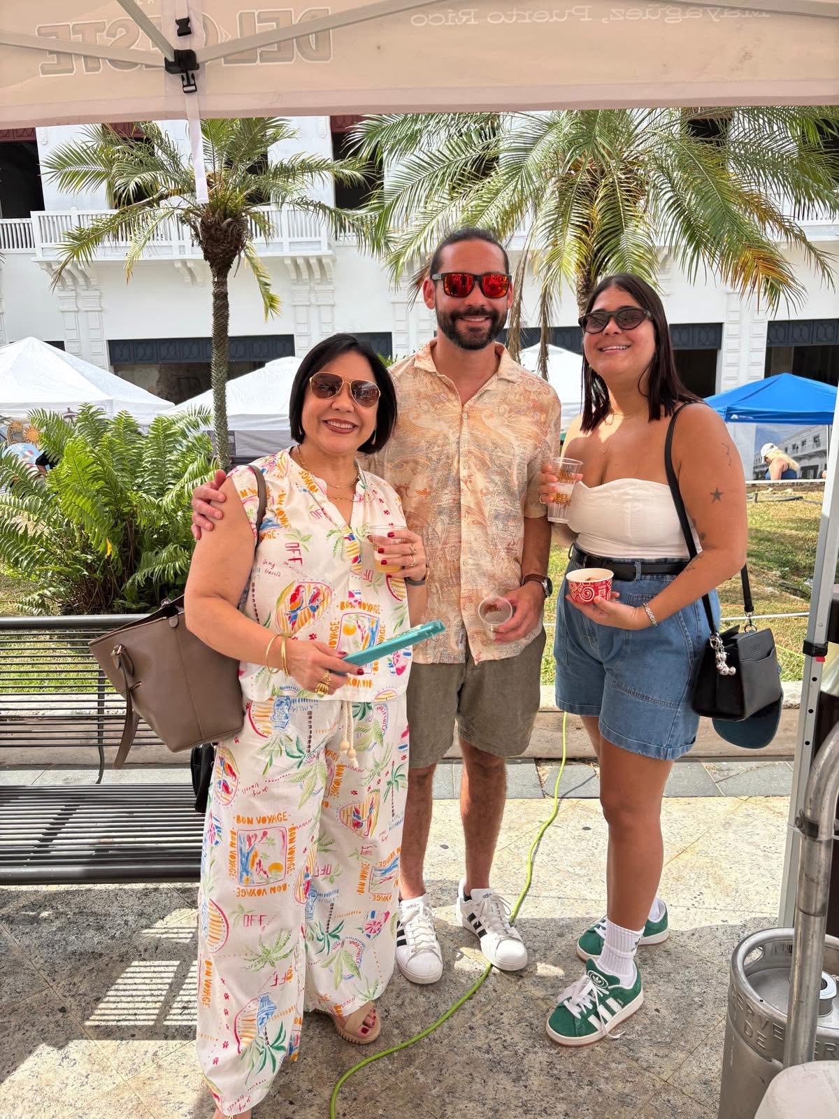 Visitantes con la cerveza artesanal de mango frente al booth de Cervezas del Oeste