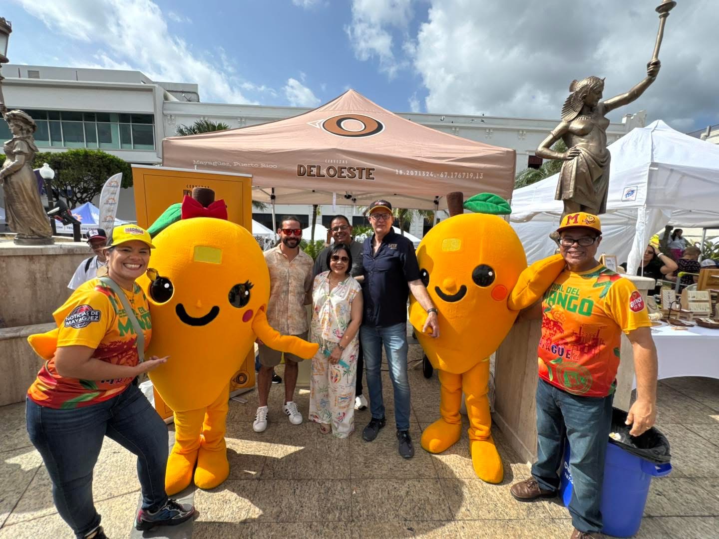 Equipo de Cervezas del Oeste con las mascotas del festival en la Plaza Pública